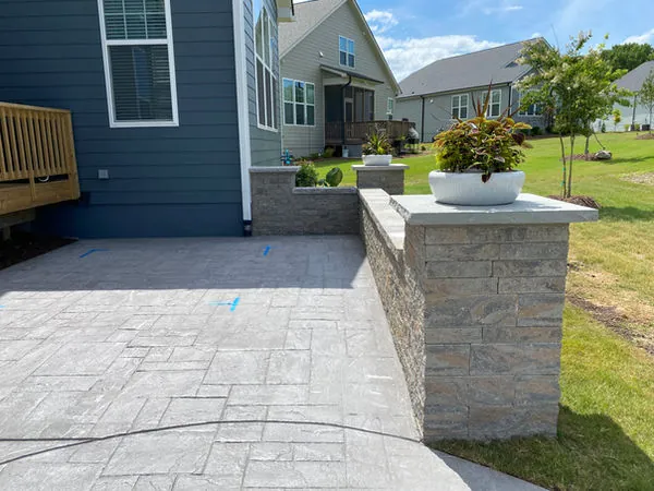 Stamped concrete patio with stone veneer columns and planter caps