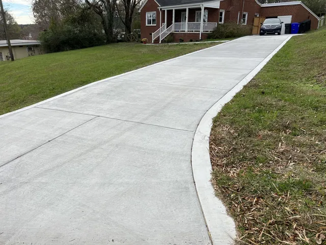 Finished concrete flatwork running alongside a lawn