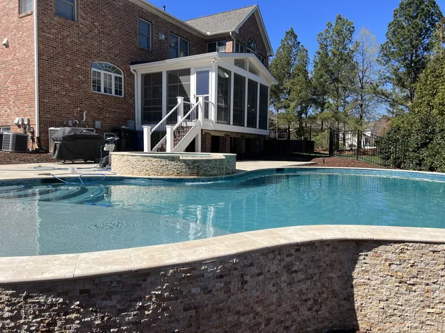 Pool deck running up to a screened porch