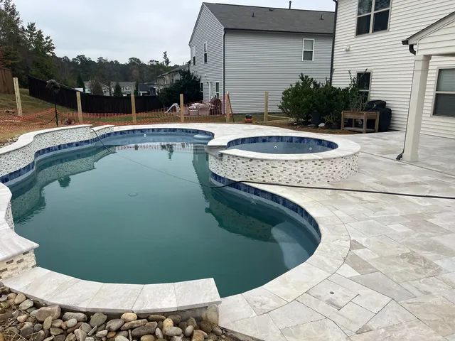 Pool and raised spa with stone coping