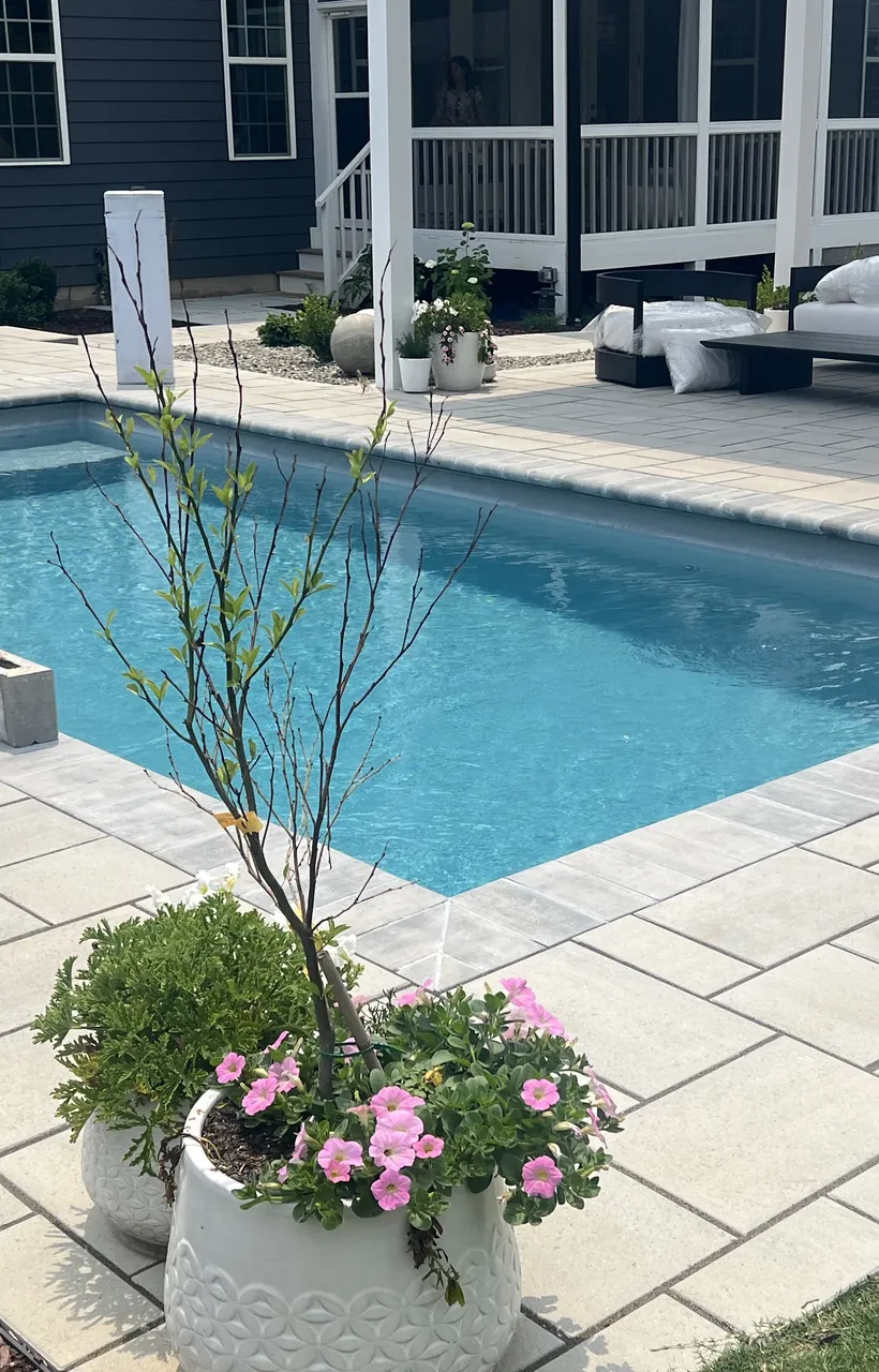 Rectangular pool with a paver deck and block seat columns