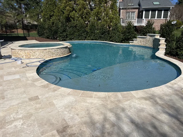 Finished pool with cut stone coping and a raised spa at one end