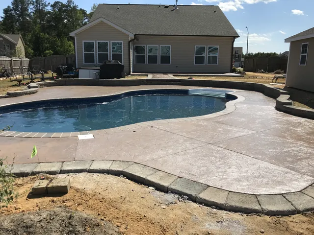Finished pool with a wide stamped concrete deck